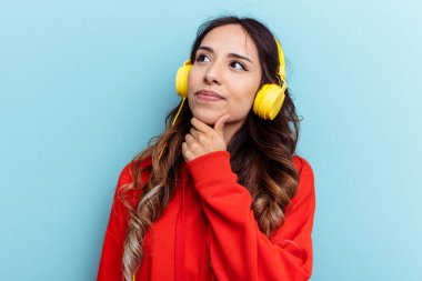 Mavi arka planda izole edilmiş genç Meksikalı kadın.