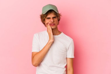 Makyajlı beyaz bir adam pembe arka planda izole edilmiş güçlü bir diş ağrısı ve azı dişi ağrısı var..