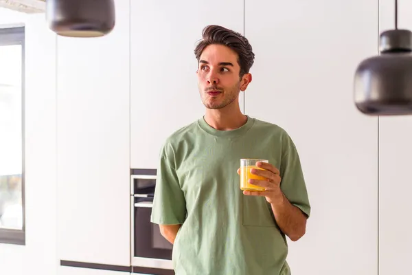 Hombre Joven Raza Mixta Bebiendo Jugo Naranja Cocina Confundido Siente — Foto de Stock