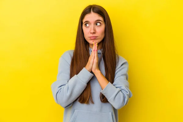 黄色の背景の祈りに孤立した若い白人女性 献身を示す 神のインスピレーションを探している宗教的な人 — ストック写真