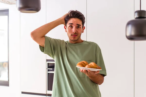 Joven Hombre Raza Mixta Comiendo Croissant Una Cocina Mañana Siendo — Foto de Stock