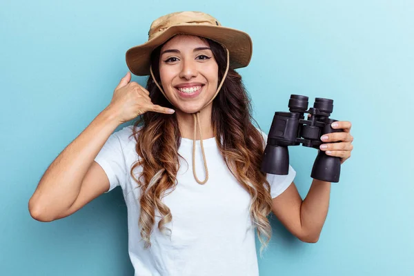 Ung Mexikansk Kvinna Håller Kikare Isolerad Blå Bakgrund Visar Mobiltelefon — Stockfoto