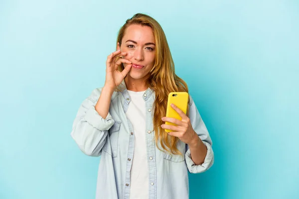 Mulher Caucasiana Segurando Telefone Celular Isolado Fundo Azul Com Dedos — Fotografia de Stock