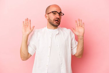 Beyaz saçlı genç adam pembe arka planda izole edildi. Yakın bir tehlike nedeniyle şok oldu.