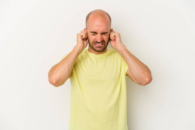 Genç kel adam beyaz arka planda izole edilmiş parmaklarıyla kulaklarını kapatan, yüksek sesli bir ortam tarafından stresli ve umutsuz..