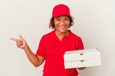 Beyaz arka planda izole pizzalar alan orta yaşlı bir kadın gülümseyen ve boş alanda bir şey gösteren bir yere işaret ediyor..