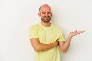 Beyaz arka planda izole edilmiş genç kel bir adam bir avuç içinde fotokopi alanı ve belinde başka bir el tutuyor..