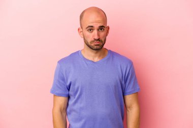 Kafkasyalı kel adam pembe arka planda izole edilmiş üzgün, ciddi yüzlü, mutsuz ve hoşnutsuz..