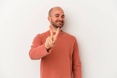 Genç kel adam beyaz arka planda izole edilmiş neşeli ve tasasız parmakları olan bir barış sembolü gösteriyor..