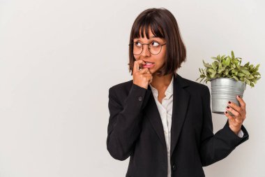 Beyaz arka planda izole edilmiş bir bitki tutan genç melez iş kadını bir şeyin fotokopi alanına baktığını düşünerek rahatladı..