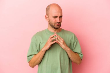 Kafkasyalı kel bir adam pembe arka planda izole edilmiş bir plan yapıyor, bir fikir kuruyor..