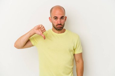 Genç kel bir adam beyaz arka planda izole edilmiş, hoşlanmadığı bir hareket sergiliyor, baş parmakları aşağıda. Anlaşmazlık konsepti.