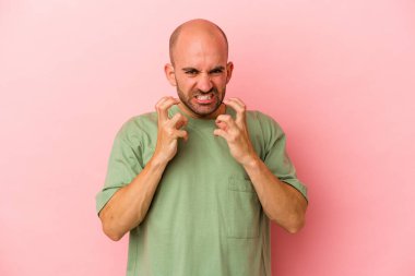 Genç beyaz kel adam pembe arka planda izole edilmiş gergin ellerle çığlık atıyor..