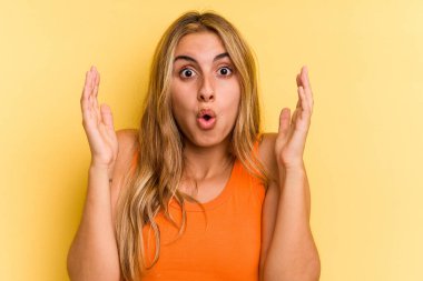 Sarışın, sarı arka planda izole edilmiş genç bir kadın. Bir fikri, ilham verici bir konsepti var..