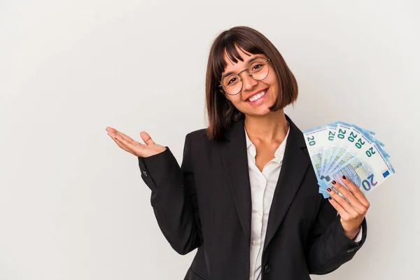 白い背景に孤立した紙幣を持ち 手のひらにコピースペースを見せ 腰にもう一方の手を握る若い混合レースビジネス女性 — ストック写真