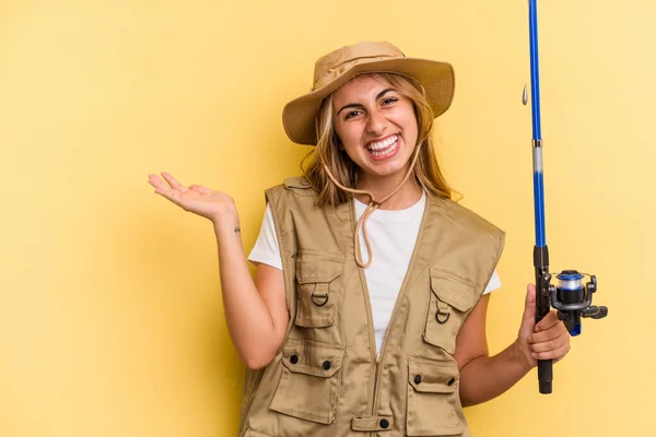 Young Caucasian Blonde Fisherwoman Holding Rod Isolated Yellow Background Showing — Stock Photo, Image
