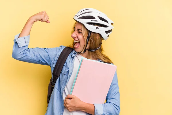 勝利の後に拳を上げ黄色の背景に隔離された自転車のヘルメットを身に着けている若い白人学生の女性 勝者の概念 — ストック写真