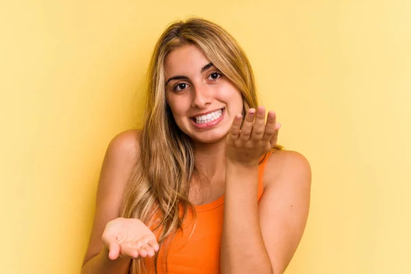 Young Caucasian Blonde Woman Isolated Yellow Background Makes Scale Arms — Stock Photo, Image