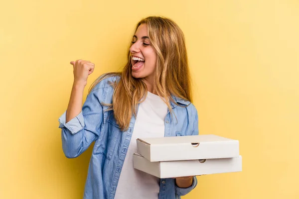 Jonge Kaukasische Blonde Vrouw Houden Pizza Geïsoleerd Gele Achtergrond Punten — Stockfoto