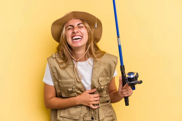 年轻的高加索金发女渔民拿着一根被黄色背景隔离的棒子 笑着玩乐 — 图库照片
