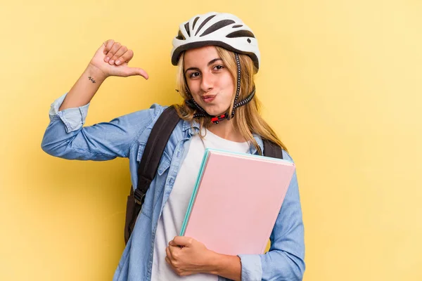 黄色の背景に隔離された自転車のヘルメットを身に着けている若い白人学生の女性は誇りと自信を感じています 次の例に従うこと — ストック写真