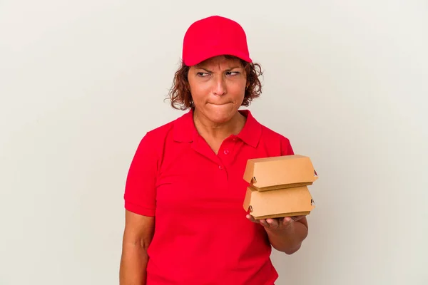 Middle Age Delivery Woman Taking Burguers Isolated White Background Confused — ストック写真