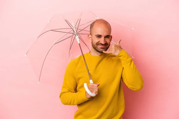 Fiatal Kaukázusi Kopasz Férfi Gazdaság Esernyő Elszigetelt Rózsaszín Háttér Mutat — Stock Fotó