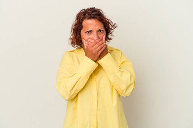 Orta yaşlı Latin bir kadın beyaz arka planda izole edilmiş, ağzı kapalı ve elleri endişeli görünüyor..