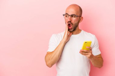 Pembe arka planda cep telefonu tutan beyaz saçlı genç adam gizli bir sıcak fren haberi veriyor ve yan bakıyor.
