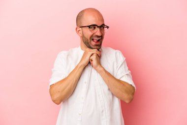 Kafkasyalı genç kel adam pembe arka planda izole edilmiş şans diliyor, şaşırıyor ve ağzını açıyor..