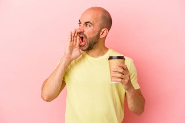 Kafkasyalı genç kel bir adam pembe arka planda izole edilmiş kahve tutuyor bağırıyor ve avuç içini açık tutuyor..