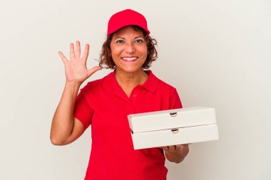 Beyaz arka planda izole pizzalar yiyen orta yaşlı kadın gülümseyerek beş numarayı parmaklarıyla gösteriyor..
