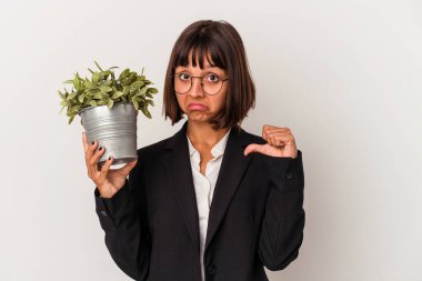 Beyaz arka planda izole edilmiş bir bitki tutan genç melez iş kadını gururlu ve kendinden emin hissediyor, örnek olarak..