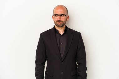 Genç ve kel bir adam beyaz arka planda izole edilmiş, kafası karışmış, şüpheli ve güvensiz hissediyor..