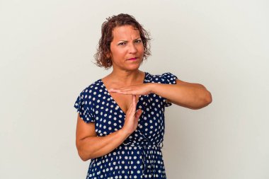 Beyaz arka planda izole edilmiş orta yaşlı Latin bir kadın bir mola hareketi gösteriyor..