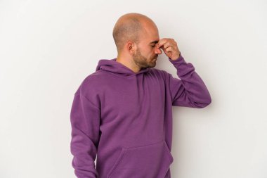 Genç kel adam beyaz arka planda izole edilmiş, başı ağrıyor, yüzüne dokunuyor..