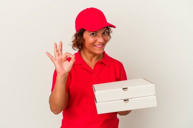 Beyaz arka planda izole edilmiş pizzaları teslim eden orta yaşlı bir kadın neşeli ve kendinden emin bir hareket sergiliyor..