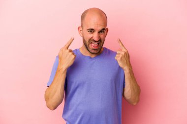 Pembe arka planda izole genç beyaz kel adam işaret parmağıyla hayal kırıklığı jesti gösteriyor..