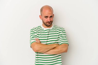 Genç kel adam beyaz arka planda izole edilmiş şüpheli, belirsiz, seni sorguluyor..
