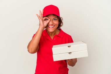 Beyaz arka planda pizza yiyen orta yaşlı teslimatçı kadın heyecanlı..