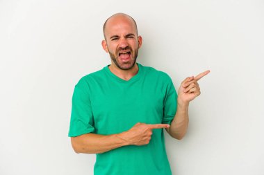 Beyaz arka planda izole edilmiş genç kel bir adam işaret parmaklarıyla fotokopi alanını işaret ederek heyecan ve arzuyu ifade ediyor..