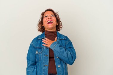 Beyaz arka planda izole edilmiş orta yaşlı Latin bir kadın yüksek sesle gülüyor elini göğsüne koyuyor..
