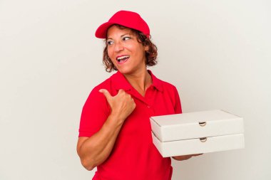 Orta yaşlı teslimatçı kadın beyaz arka planda izole edilmiş pizzalar alıyor başparmak uzakta, gülüyor ve kaygısız..