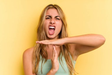 Sarışın, genç bir kadın sarı arka planda izole edilmiş..