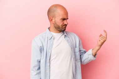 Kafkasyalı genç kel adam pembe arka planda izole edilmiş seni işaret ediyor sanki davet ediliyormuş gibi..