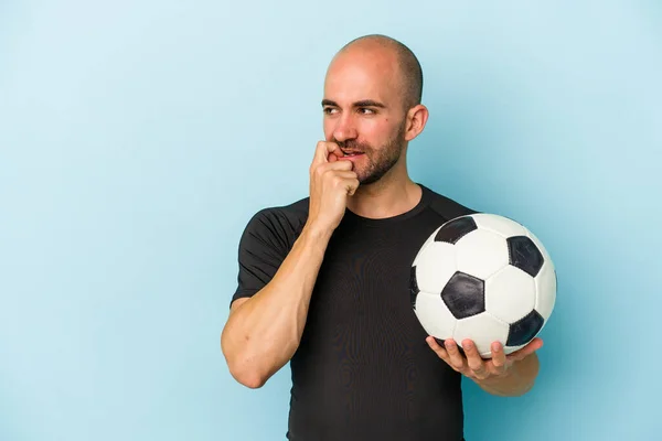 年轻的商业秃头男子在蓝色背景下打足球放松地思考着什么东西看着一个复制的空间 — 图库照片