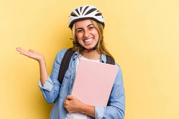 若いです白人学生女性を身に着けています自転車ヘルメット黄色の背景に隔離されたヤシの上にコピースペースを示し 腰に別の手を保持 — ストック写真