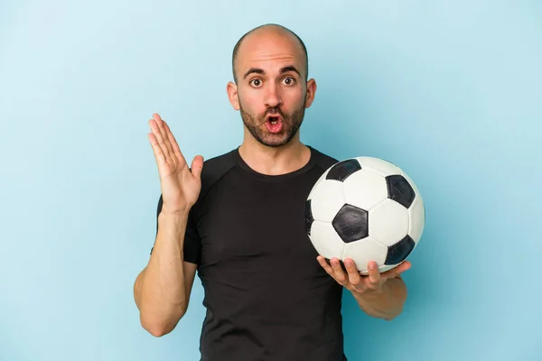 Jovem Homem Careca Negócios Jogando Futebol Isolado Fundo Azul Surpreso — Fotografia de Stock