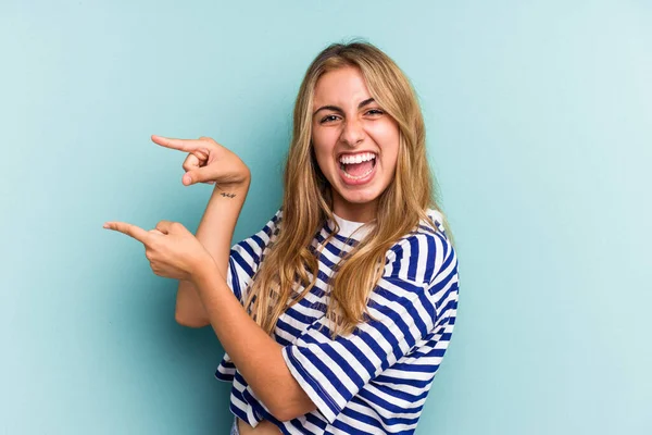 Joven Mujer Rubia Caucásica Aislada Sobre Fondo Azul Excitada Señalando — Foto de Stock