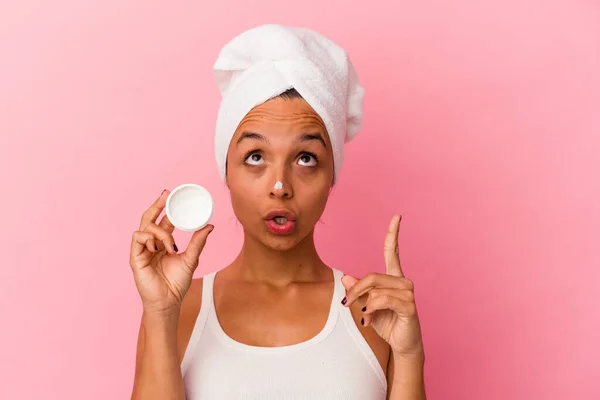 Joven Mujer Mestiza Sosteniendo Crema Facial Aislada Sobre Fondo Rosa — Foto de Stock